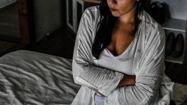 Angry woman with arms crossed sitting on a bed